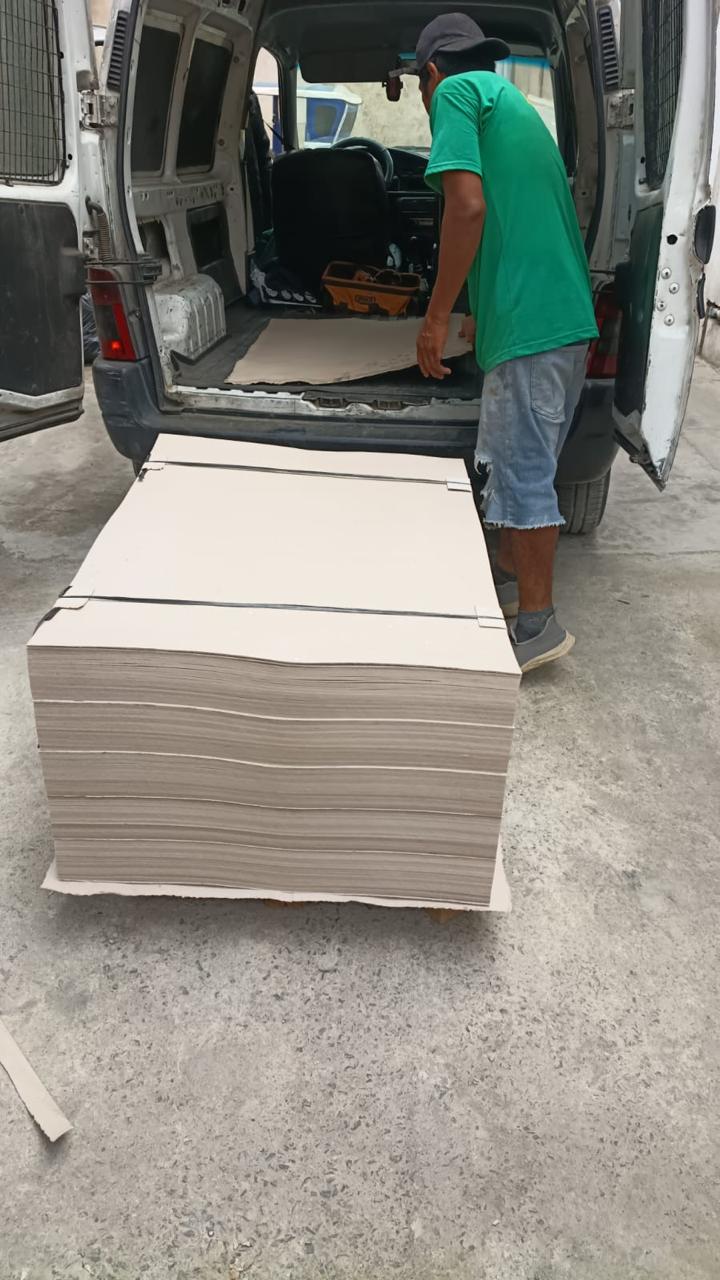 Carga de planchas de cartón gris para entrega a provincia