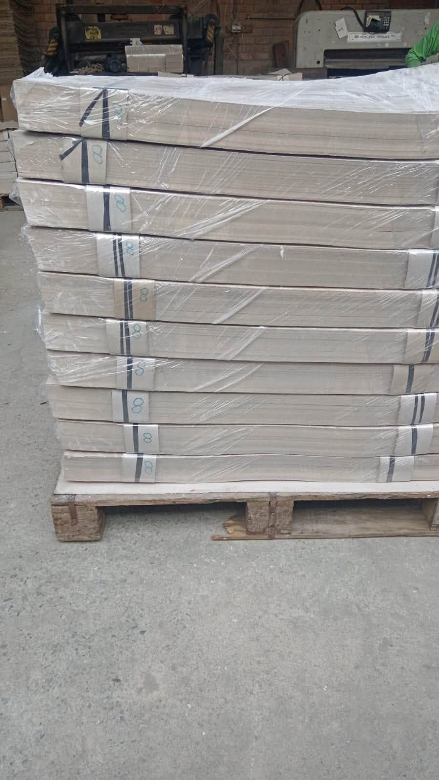 Pallet con paquetes de cartón gris embalados en film listos para despacho