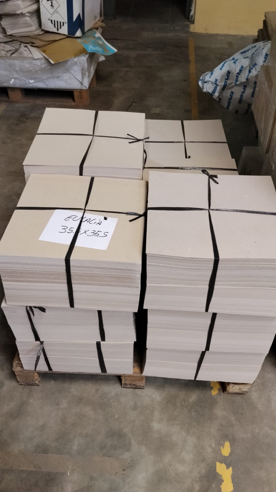 Paquetes de cartón gris cortado y atado sobre pallets